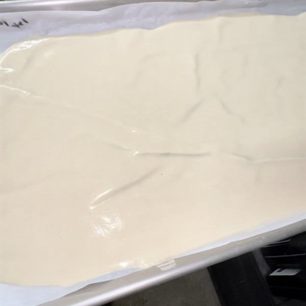 Large sheet of freshly pressed rosin on parchment in a tray